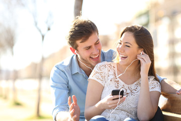 Joyful couple listening to online music together