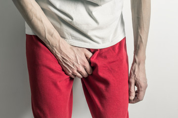 Prostatitis, inflammation of the bladder. Premature ejaculation. Man holding penis. 