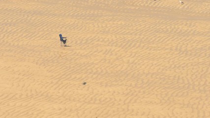 An abandoned fold up chair, on a hot day, on St Ives beach, Cornwall.