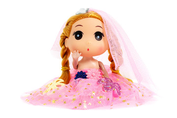 Cute doll is sitting in a pink dress, as princess with flowers on white background