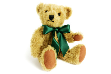 Cute teddy bear is sitting with raise paw, toy is made from golden mohair complemented with pure...