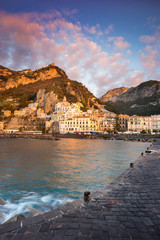 view to pier and harbor with Amalfi coast in Italy in sunset with clouds