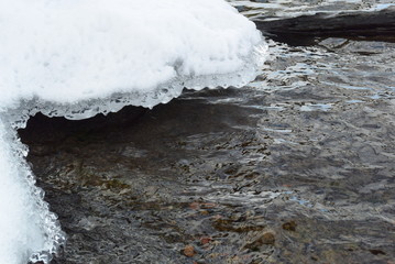 Large ice chunks floating down a river in the middle of winter. Photo is taken from an aerial view.