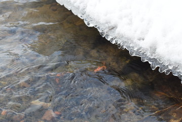 Large ice chunks floating down a river in the middle of winter. Photo is taken from an aerial view.
