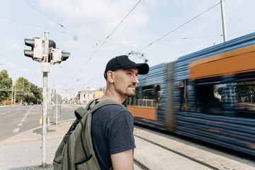 Young guy or male tourist on a street or a crossroads or near the road in Leipzig in Germany. Near...