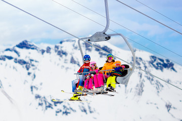 Family in ski lift in mountains. Skiing with kids - obrazy, fototapety, plakaty