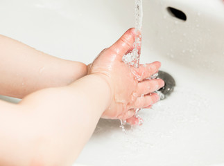 Fototapeta premium Young child washing hands with colorful soap. Hygine concept.