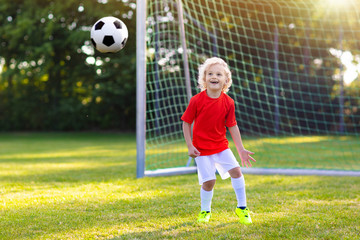 Kids play football. Child at soccer field.