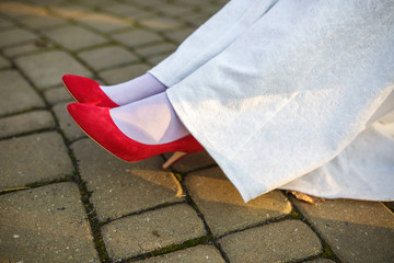 red shoes on the feet of the bride in a white dress
