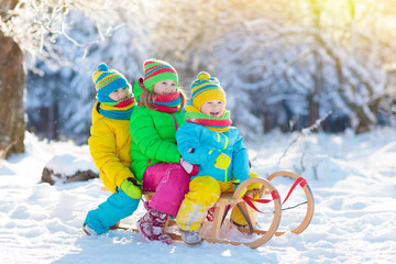 Kids play in snow. Winter sled ride for children