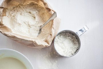 Ingredients for baking cake laid out on a white wooden table. selective focus