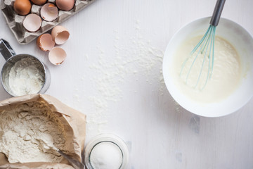 Ingredients for baking cake laid out on a white wooden table. selective focus