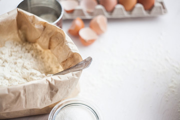 Ingredients for baking cake laid out on a white wooden table. selective focus