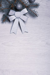 Silver bow on a background with a branch of the Christmas tree.