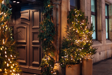 massive wooden door of the building and Christmas trees are deco