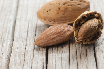 Raw almond nut in shell on wooden table. Almonds background concept.