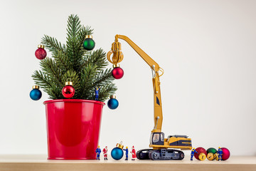 Miniature workers decorating christmas tree