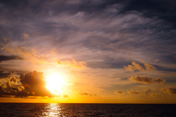 Dramatic sunset sky as storm clouds compute over sea horizon during dusk