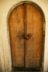 Old arched door made of natural wood.