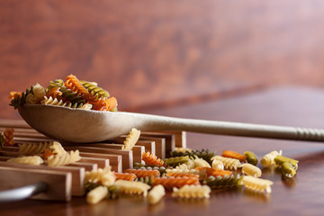 CUCHARA DE MADERA SOBRE PARRILLA DE MADERA CON ESPIRALES DE PASTA