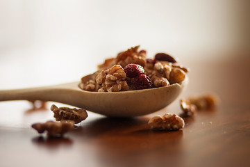 CUCHARÓN DE MADERA A CONTRALUZ CON NUECES Y ARÁNDANOS