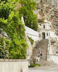 A staircase leading to the church at the foot of a large cliff