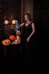 a woman in a black dress for Halloween holding a lantern in her hands