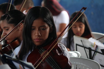 woman playing violin in front of music background © Camilo Tello