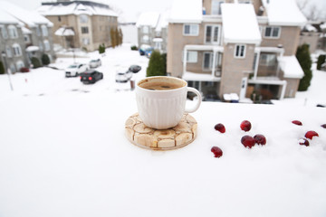 cup of coffee in the snow against the background of the street