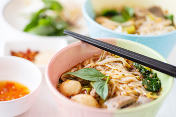 Spicy rice noodles soup in a bowl with chopsticks, Thai food