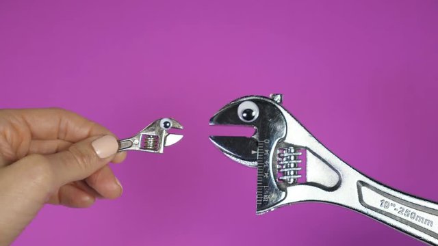 Cute fun portrait of baby wrench with eyes talking to big parental wrench with eyes. Ending with a kiss. Video for kids. Parenthood. Purple background. 
