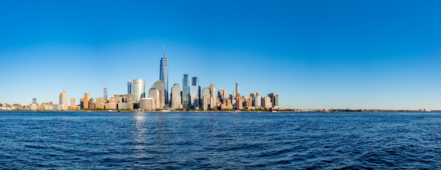 Panorama of skyline of downtown Manhattan over Hudson River under blue sky, in New York City, USA