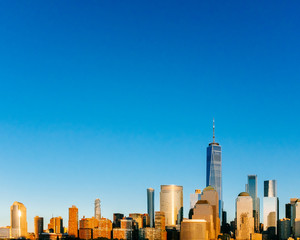 Skyline of downtown Manhattan under blue sky, at sunset, in New York City, USA