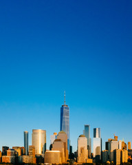 Skyline of downtown Manhattan under blue sky, at sunset, in New York City, USA