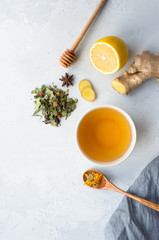 Herbal tea and lemon, ginger, honey on concrete background with copy space. Top view. Vertical photo. 