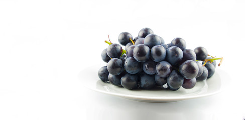  Tasty fresh black grape in a bowl and on white background