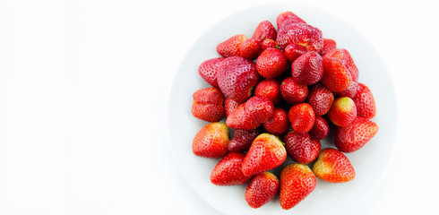 Tasty fresh red strawberry in a bowl and on white background