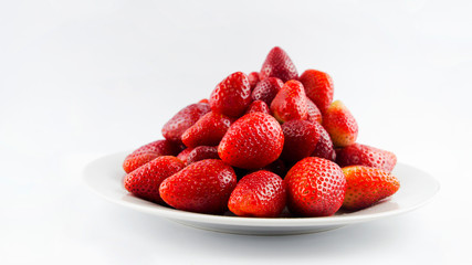 Tasty fresh red strawberry in a bowl and on white background