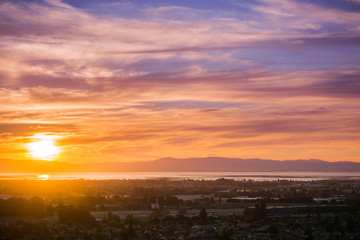 Sunset view of Hayward and Union City from Garin Dry Creek Pioneer Regional Park, east San Francisco bay shoreline and San Mateo bridge in the background, California