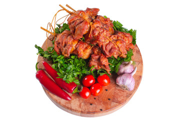 Smoked pork shish kebab on skewers with vegetables and greens on white isolated in plan