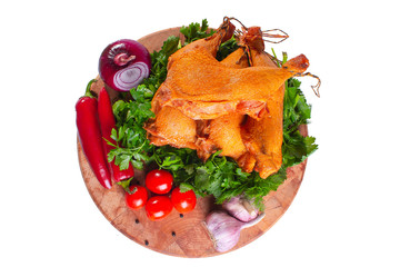 Smoked chicken ham with vegetables and greens on a wooden round board on a white isolated background