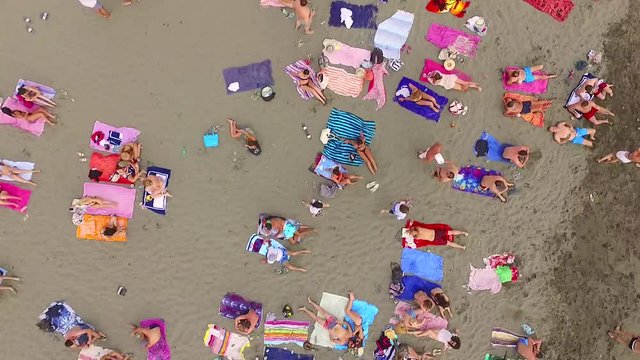 People on the beach. Aerial view of people sunbathing on the beach. Aerial view from flying drone of people crowd relaxing on beach