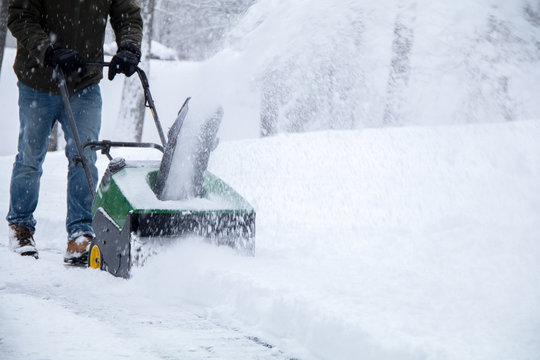 Snowblower in action during a snowstorm in the Northeast, maintaining driveway during Nor'Easter blizzard