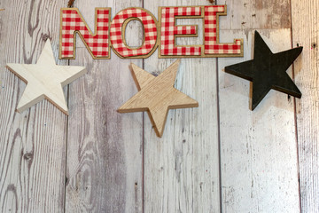 Rustic Christmas holiday flatlay with wood stars, red and white plaid Noel word on wood background