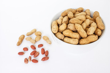 peanut pile in white bowl top view on white background