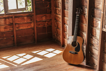 Old guitar classic in room on wall wooden.