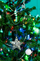 Christmas tree with new year toys close up. Bright color, garlands, silver star
