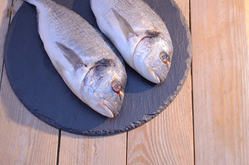 dorado fish on a black plate and wooden table