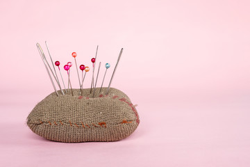 sewing pins on pink background.