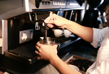 Barista preparing milk for takeaway coffee. Close-up